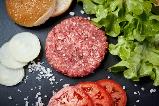 fresh beef for burger on the table with lettuce, onion and bread