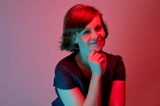 Beautiful attractive young woman posing in neon light in the studio