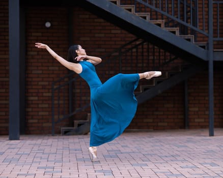 Beautiful Asian ballerina dancing outdoors. Urban landscape