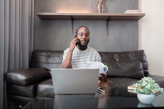 Professional man working remote from home with technology. African American male has a business meeting on an audio call phone.