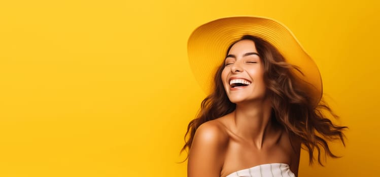 Summer portrait of happy laughing young woman in straw hat on yellow studio background, blank copy space for advertising text