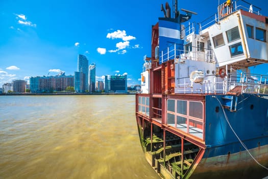 A Slice of Reality boat remains on Thames river and Canary Wharf in London view, capital of UK