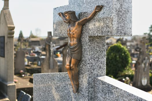 Crucified Jesus Christ on a cross on a grave in a European cemetery