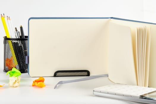The notebook is next to other accessories. In the middle is a blank notepad page for typing.