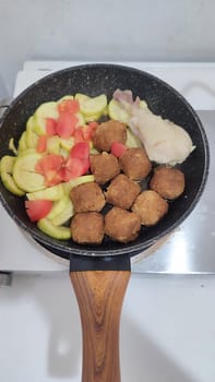 zucchini, tomatoes, chicken and cutlets, meatballs in a frying pan, homemade food, cooking. High quality photo