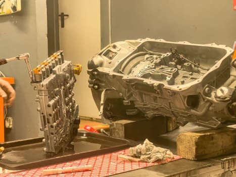 Close-up of mechanical repairs on an automatic gearbox during servicing or refurbishment.