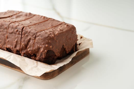 Fresh homemade chocolate sponge cake on wooden board close up