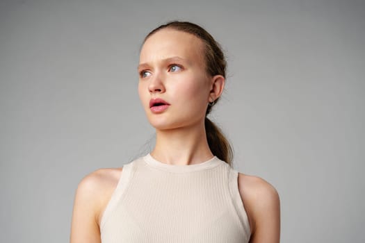 Startled Woman With Surprised Expression on gray background in studio