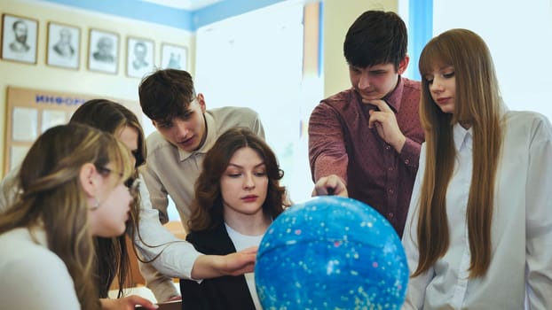 Students look at a globe of the starry sky in a classroom at school