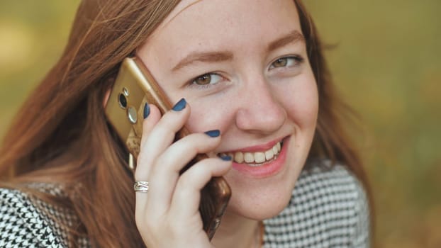 A young girl talking on the phone. Close-up of her face