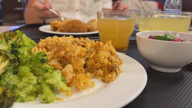 Broccoli with a dish of pilaf on the table while dining with friends