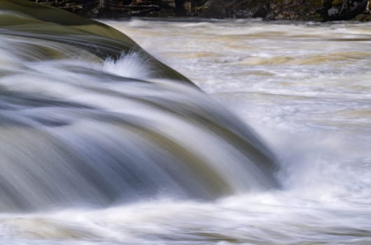 Silky blurred exposure of raging water flowing over rocks of Valley Falls State Park on Tygart River near Fairmont West Virginia