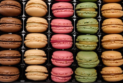 Multi-colored macarons in a plastic box, top view. Assortment