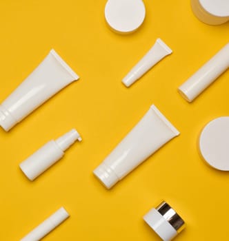 Various types of white plastic packaging, bottle, jar, tube on a yellow background. Container for cosmetics