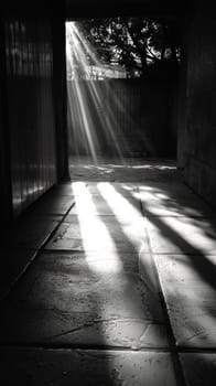 A black and white photo of a hallway with sunlight coming through