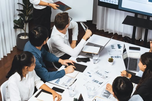 Project manager communicate and collaborate with team using project management software display on monitor, tracking progress of project task and making schedule plan at meeting table. Prudent