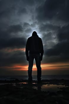 A person standing on a beach with the sun setting behind them