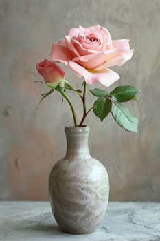 A vase with two pink roses in it on a table