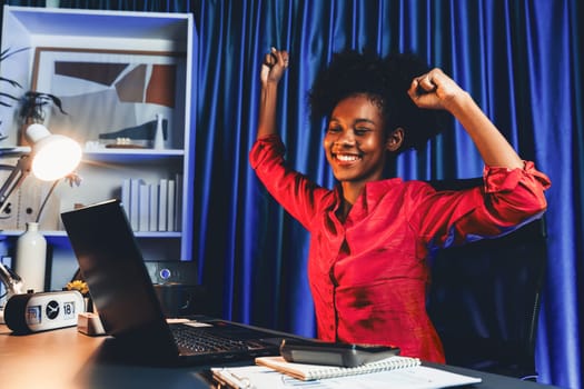 Working African woman with happy glowing, smiling face, getting new job project with good deal or marketing course scholarship information on laptop screen. Concept of cheerful expression. Tastemaker.