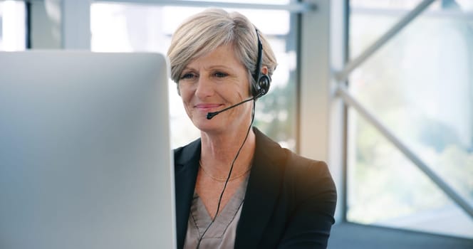 Call center, computer and headset with mature telemarketing employee in office for consulting. Contact us, customer service and support with happy business woman in workplace for assistance or help.