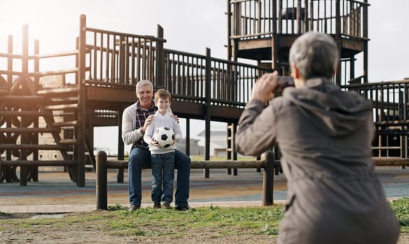 Grandparents, child and cellphone picture at park for bonding with soccer ball, playground and photography. Person, back and smartphone photo for family memory or social media, post or online.