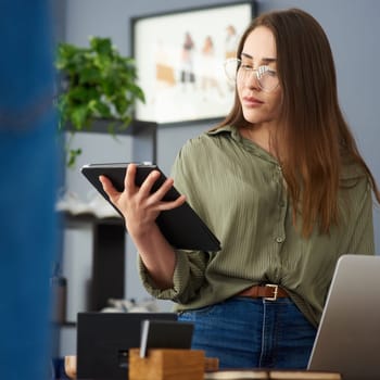 Woman, tablet and thinking in startup office with app, time management and creative project for copywriting. Girl, person and staff writer with digital touchscreen for idea, notes and vision at job.