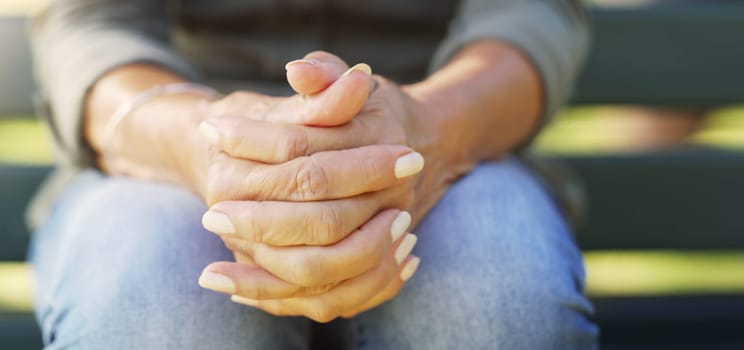 Hands, nervous and worry with person thinking outdoor on bench for anxiety, depression or stress. Mental health, prayer and wellness with adult closeup in garden or park for fail, mistake and regret.