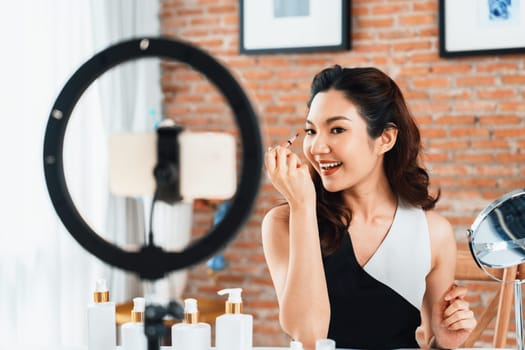 Woman influencer shoot live streaming vlog video review makeup uttermost social media or blog. Happy young girl with cosmetics studio lighting for marketing recording session broadcasting online.