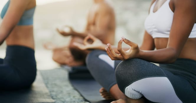 Hands, meditation and yoga at beach for fitness, exercising and mindfulness or wellness outdoor. Class, friends or people meditate with workout or balance for spiritual, strength and mental health.