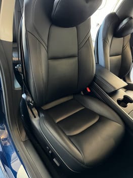 Castle Rock, Colorado, USA-March 14, 2024-The interior of a Tesla Model 3, featuring its premium black seats and modern dashboard, receives a meticulous cleaning in the garage of a private residence.