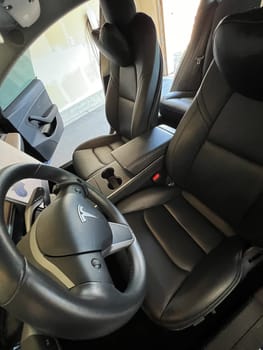 Castle Rock, Colorado, USA-March 14, 2024-The interior of a Tesla Model 3, featuring its premium black seats and modern dashboard, receives a meticulous cleaning in the garage of a private residence.