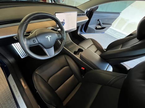 Castle Rock, Colorado, USA-March 14, 2024-The interior of a Tesla Model 3, featuring its premium black seats and modern dashboard, receives a meticulous cleaning in the garage of a private residence.