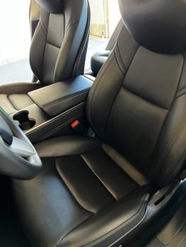 Castle Rock, Colorado, USA-March 14, 2024-The interior of a Tesla Model 3, featuring its premium black seats and modern dashboard, receives a meticulous cleaning in the garage of a private residence.