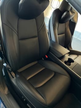 Castle Rock, Colorado, USA-March 14, 2024-The interior of a Tesla Model 3, featuring its premium black seats and modern dashboard, receives a meticulous cleaning in the garage of a private residence.