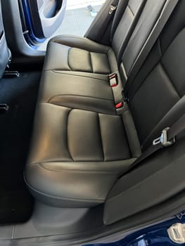 Castle Rock, Colorado, USA-March 14, 2024-The interior of a Tesla Model 3, featuring its premium black seats and modern dashboard, receives a meticulous cleaning in the garage of a private residence.