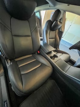 Castle Rock, Colorado, USA-March 14, 2024-The interior of a Tesla Model 3, featuring its premium black seats and modern dashboard, receives a meticulous cleaning in the garage of a private residence.