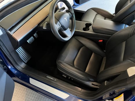 Castle Rock, Colorado, USA-March 14, 2024-The interior of a Tesla Model 3, featuring its premium black seats and modern dashboard, receives a meticulous cleaning in the garage of a private residence.