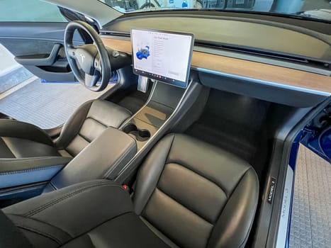 Castle Rock, Colorado, USA-March 14, 2024-The interior of a Tesla Model 3, featuring its premium black seats and modern dashboard, receives a meticulous cleaning in the garage of a private residence.