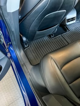 Castle Rock, Colorado, USA-March 14, 2024-The interior of a Tesla Model 3, featuring its premium black seats and modern dashboard, receives a meticulous cleaning in the garage of a private residence.