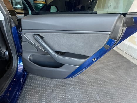 Castle Rock, Colorado, USA-March 14, 2024-The interior of a Tesla Model 3, featuring its premium black seats and modern dashboard, receives a meticulous cleaning in the garage of a private residence.