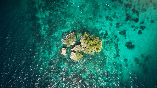 Drone, ocean or island and rock in water for summer adventure, travel location or holiday destination. Aerial view, beach or natural environment with tropical landscape or sea background in Indonesia.