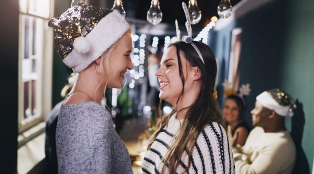 Woman, lesbian and couple at Christmas party for lgbt celebration, romance or love. Female people, smile and queer pride at social event with friends for festive season or holiday, home or gathering.