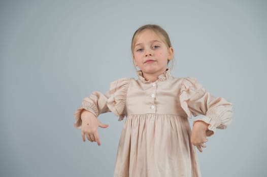 Little Caucasian girl having fun and making faces on a white background