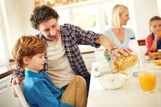 Father, breakfast and boy in house for eating, happiness and kids at table in morning for nutrition. Dad, mom and wellness indoors for weekend fun, children and couple in kitchen for bonding.