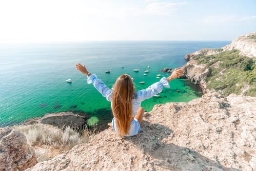 Woman travel sea. Happy woman in a beautiful location poses on a cliff high above the sea, with emerald waters and yachts in the background, while sharing her travel experiences.