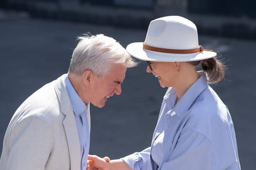 Stylish elderly laughing couple on a walk. Romantic relationships of mature people