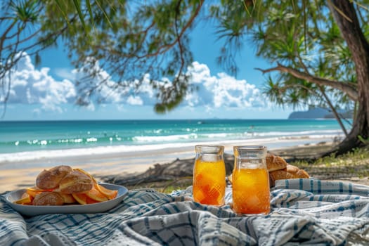 A picnic scene with food and glass of orange juice drink on picnic blanket at beach.