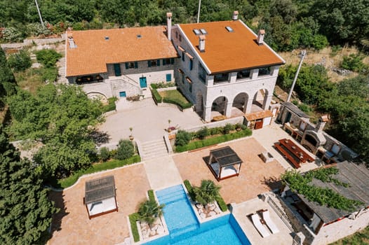 Gazebos with sun loungers stand in the courtyard of an ancient villa near the pool. Top view. High quality photo