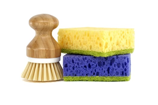 Sponges, each a different color yellow and blue near kitchen scrub brush with wooden handle isolated on white background, cleaning tools