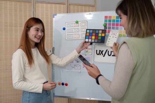 ux developer and ui designer presenting mobile app interface design on whiteboard in meeting at office. Creative digital development mobile app agency. digital transformation.